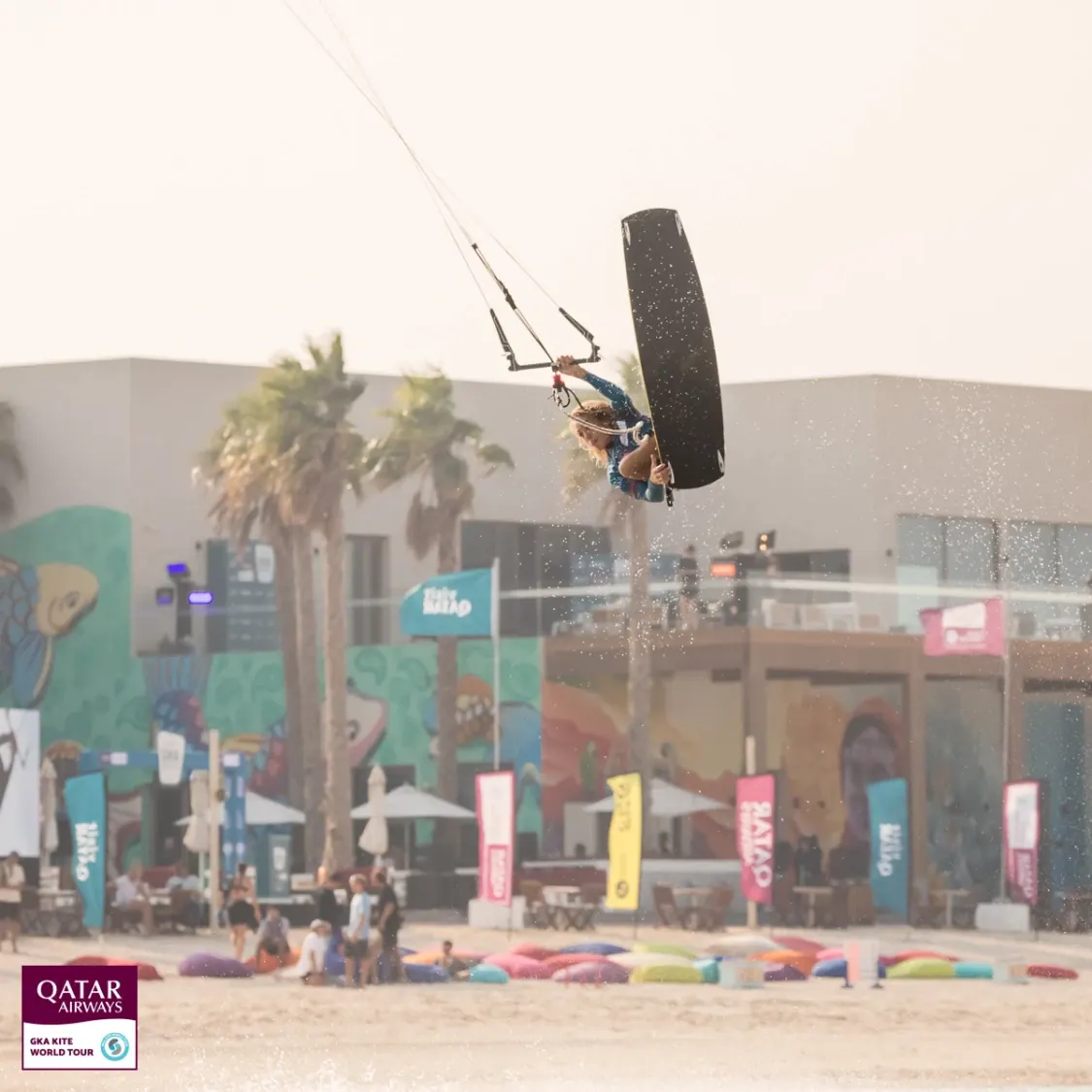 Finn Flügel mid-air, holding his board away from his feet, at the GKA Freestyle World Cup in Qatar, 2023