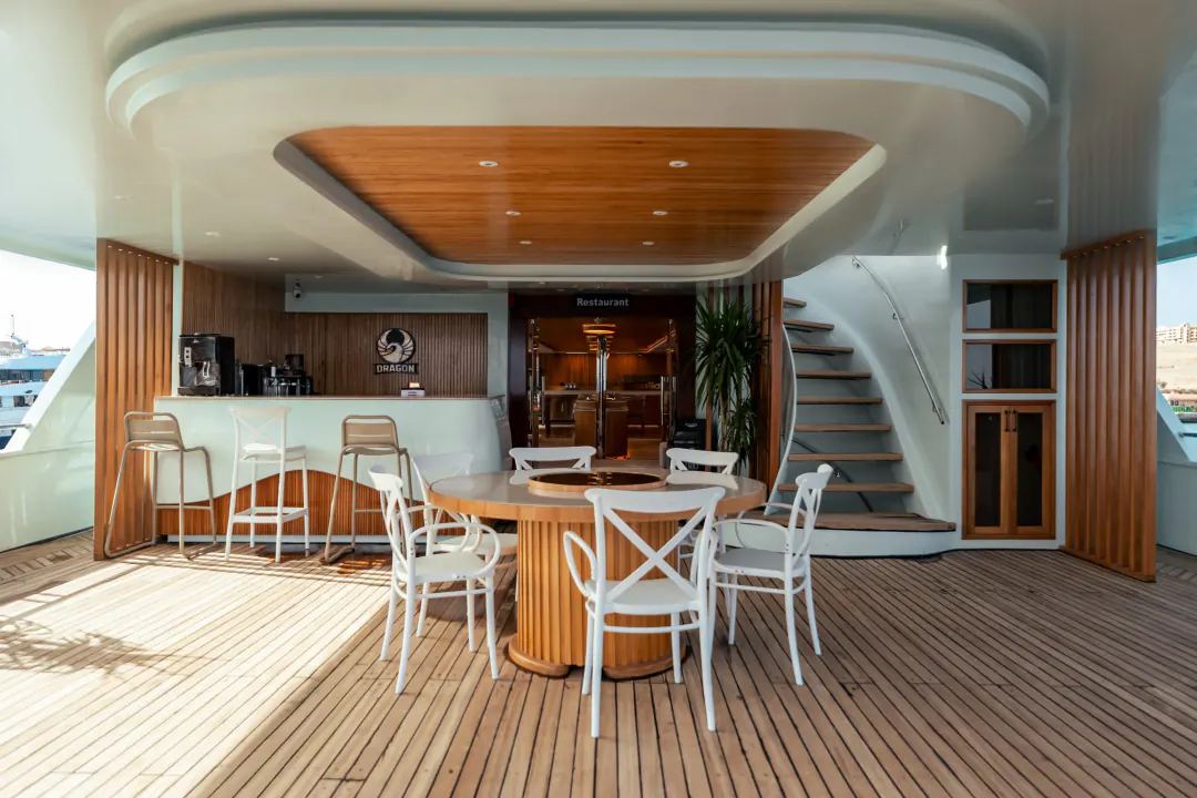 The bar on the aft deck: a counter with bar stools, a round table in front of it, the entrance to the restaurant behind