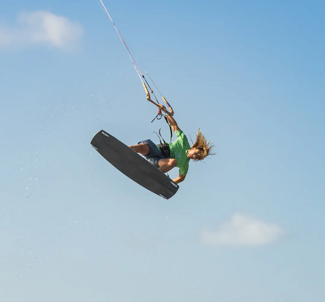 Finn in a green jersey high in the air above the water